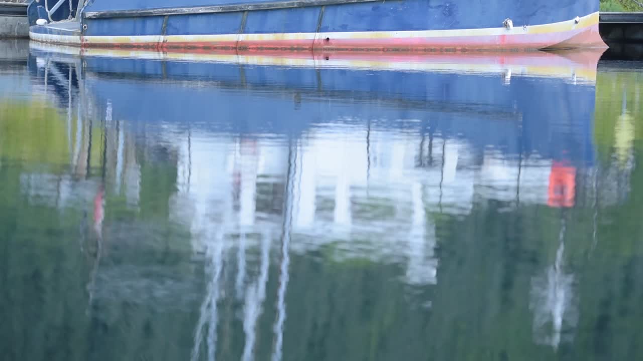 The Crystal Clear Reflection Of The Motor Boat In The Waters Of Caledonian Canal In Scotland. -wide shot