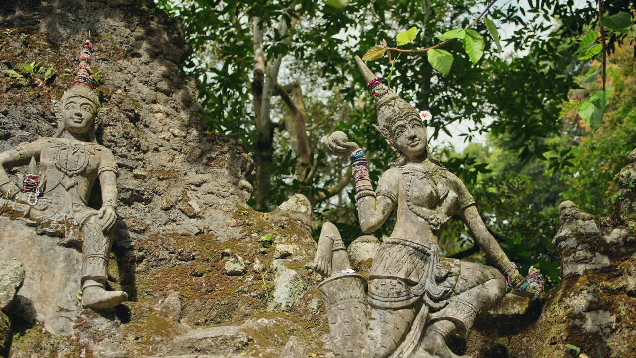Antiguas estatuas de piedra en un exuberante jardín selvático tropical