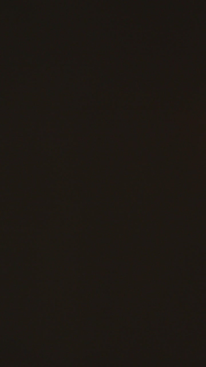 Vertical Video Close Up Of Person Wrapped In Blanket Holding Candle To Save Electricity