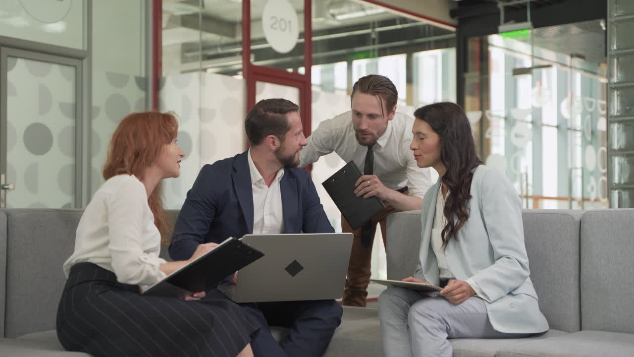 equipo de trabajo compuesto por dos mujeres y dos hombres en una reunión puso cosas en común con una computadora portátil en un ambiente relajado