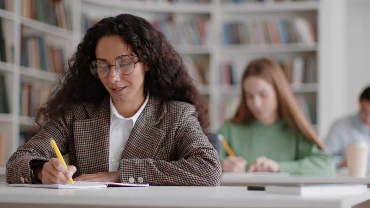 Focused Students Writing and Studying in a Library