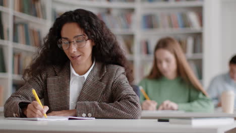 focused students writing and studying in a library