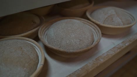 Bread-dough-blanks-in-old-raffia-baskets-in-a-bakery