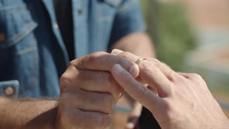 slow motion of man putting engagement ring on boyfriend's finger