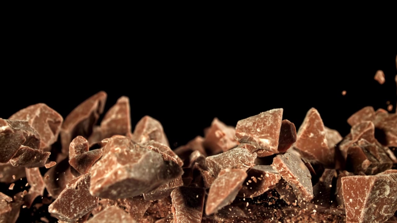 Slow Motion of Chocolate Chunks Falling on Black Background