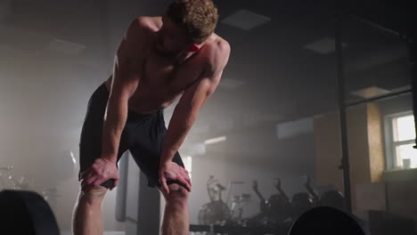 un atleta agotado por el entrenamiento en el gimnasio después de realizar el ejercicio descansa y gana fuerza. un hombre denso y fuerte se recupera durante un entrenamiento