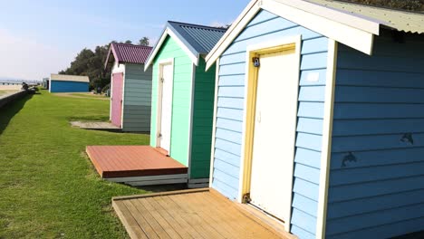 vibrant beach boxes along a grassy path