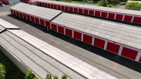 aerial orbit shot of red garages or warehouse temporary storages in american suburb