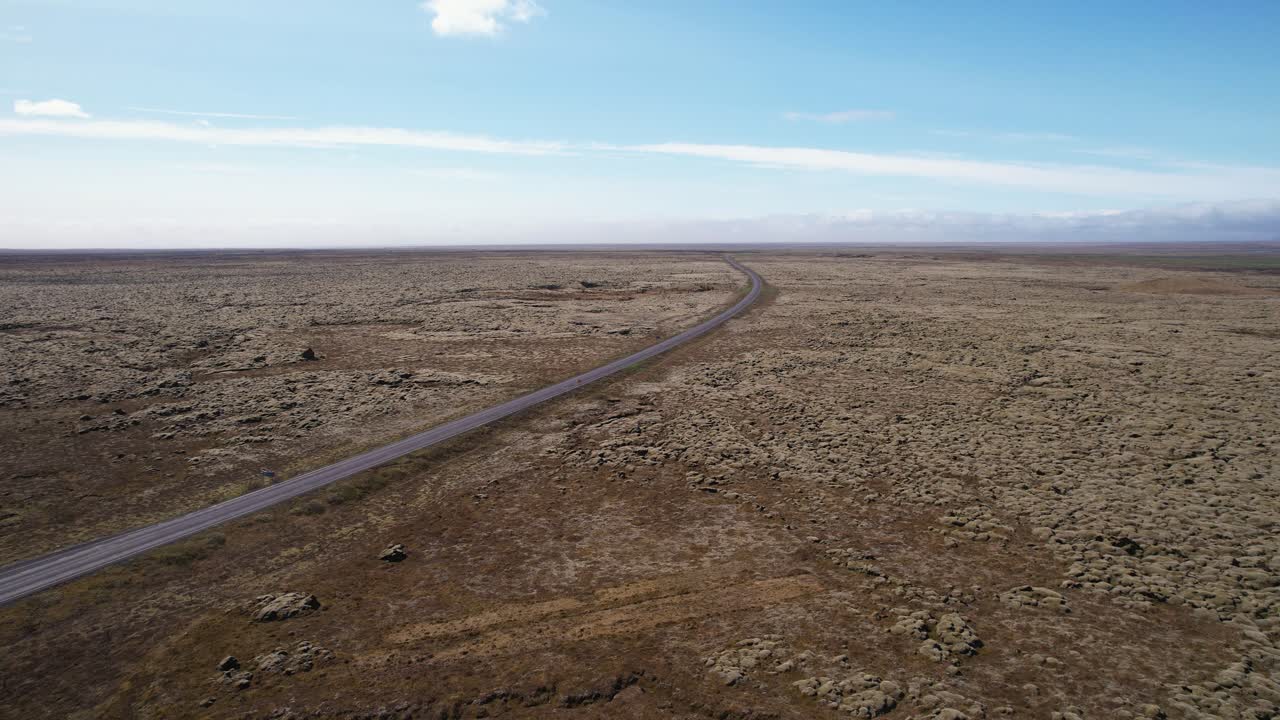 vista aérea de una carretera desierta que atraviesa un paisaje estéril bajo un cielo despejado en islandia