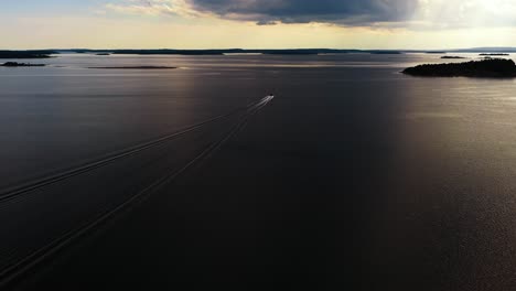 aerial view of a boat driving in the aland archipelago, dramatic sunset in finland