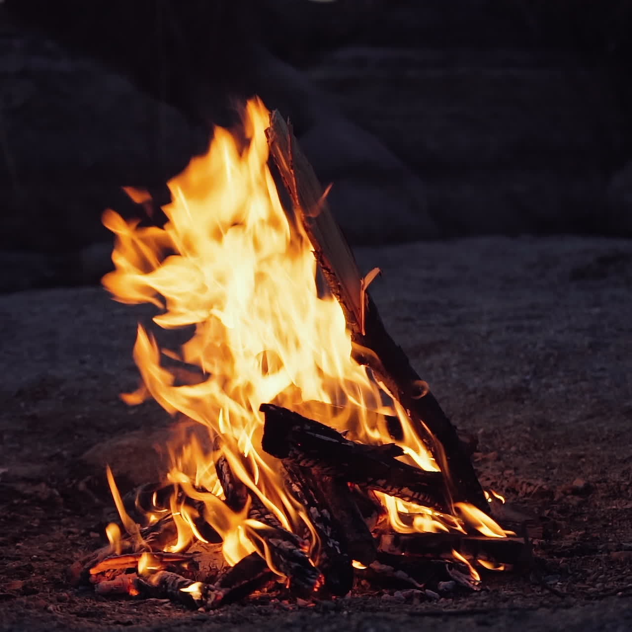 A closeup of a campfire. Beautiful fire burns brightly. Embers of the fire climb up. Slow motion