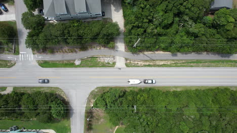 Drone-shot-of-person-riding-a-bike-on-a-coastal-highway,-downward-angle