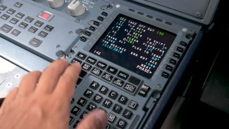 mano del piloto ingresa parámetros de vuelo, preparando la aeronave