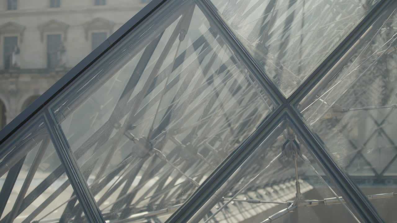 detalle de la pirámide de vidrio del louvre en parís, tiro inclinado a cámara lenta