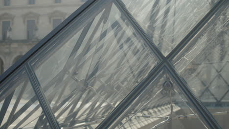 Detail-of-the-louvre-glass-pyramid-in-paris,-slow-motion-tilt-up-shot