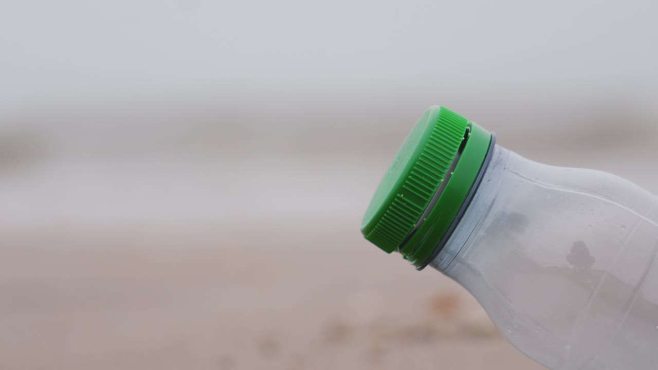 Tapa de botella de plástico en un entorno natural abandonada por un consumidor en un día oscuro y nublado. Basura contaminante