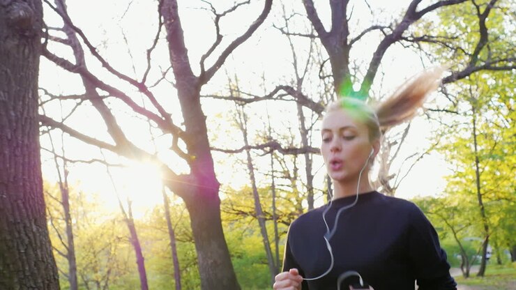 бег трусцой в лесу на фоне заходящего солнца привлекательная женщина бежит на солнце sl