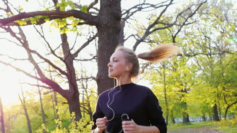 Joggen-Im-Wald-Vor-Dem-Hintergrund-Der-Untergehenden-Sonne-Eine-Attraktive-Frau,-Die-In-Der-Sonne-Läuft