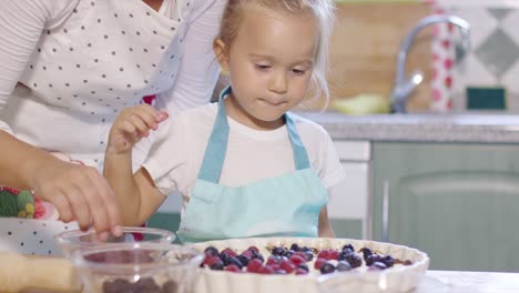 Mutter-Und-Tochter-Geben-Frische-Beeren-In-Einen-Kuchen