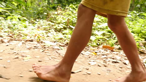 child walking barefoot in a tropical forest