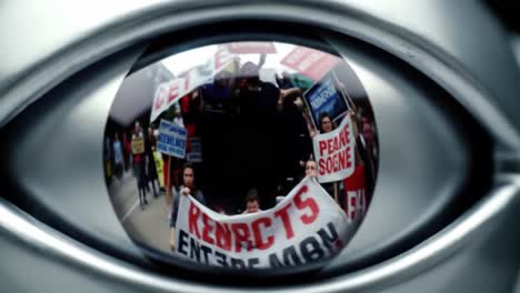 reflection of a demonstration in an eye, capturing protesters holding signs with passionate messages for change and social justice