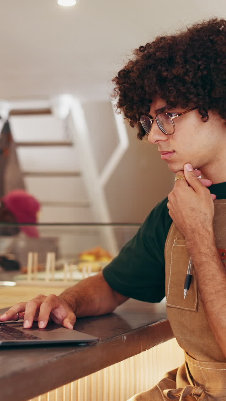Waiter with curly hair at a bakery counter