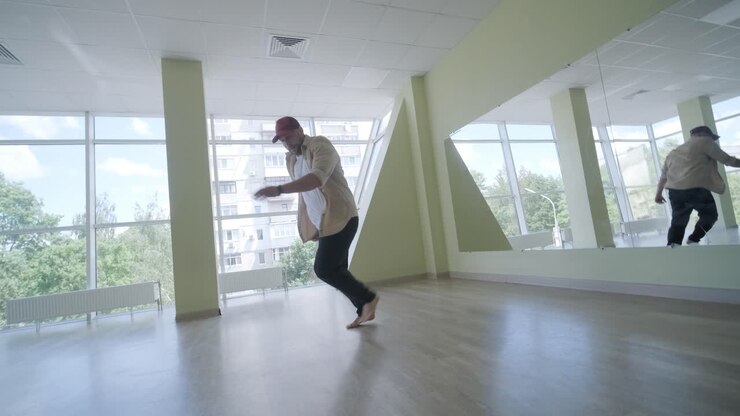 Giovane uomo elegante che balla break dance e coreografie. Concetto di performance, movimento, stile e moda