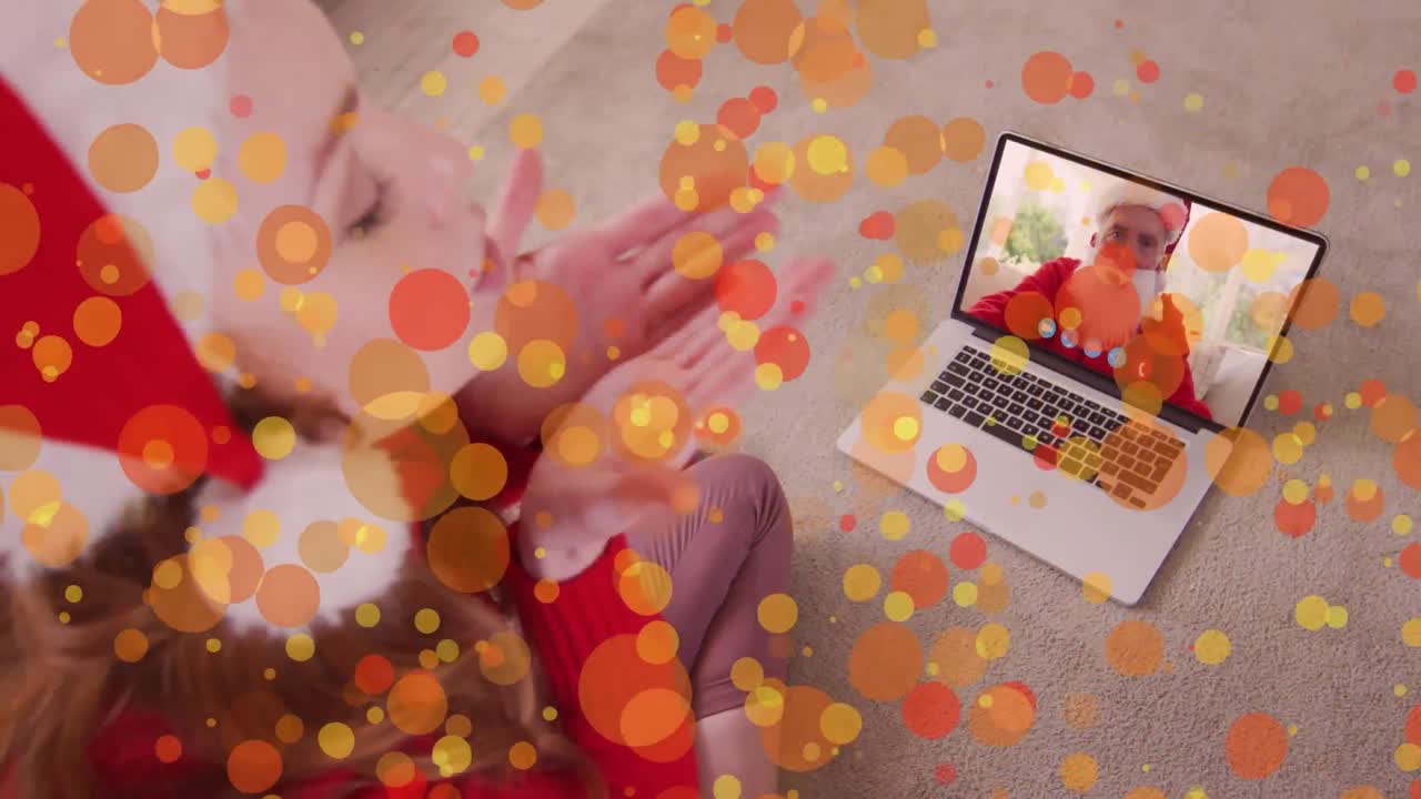 animación de puntos de luz sobre mujer caucásica en sombrero de santa en llamada de video portátil en navidad