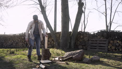 Hombre-Caucásico-Cortando-Leña-Con-Un-Hacha-Fuera-De-Una-Casa-De-Campo