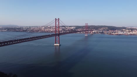 high stationary drone shot over bay harbour and red suspension bridge in portugal lisbon