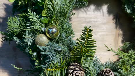 christmas wreath with hanging christmas balls on wooden front door