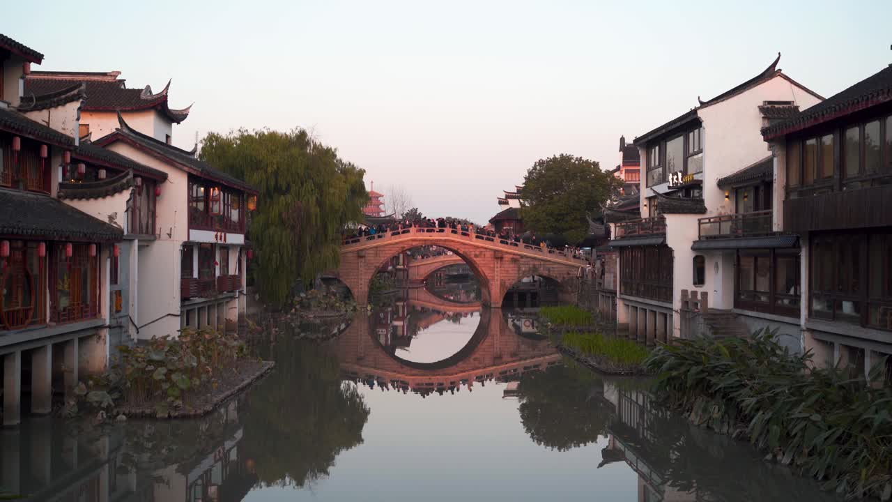 Old stone bridge over calm stream at Zhujiajiao Water Town in Shanghai, China