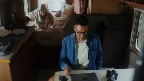 pareja relajándose y trabajando en una caravana