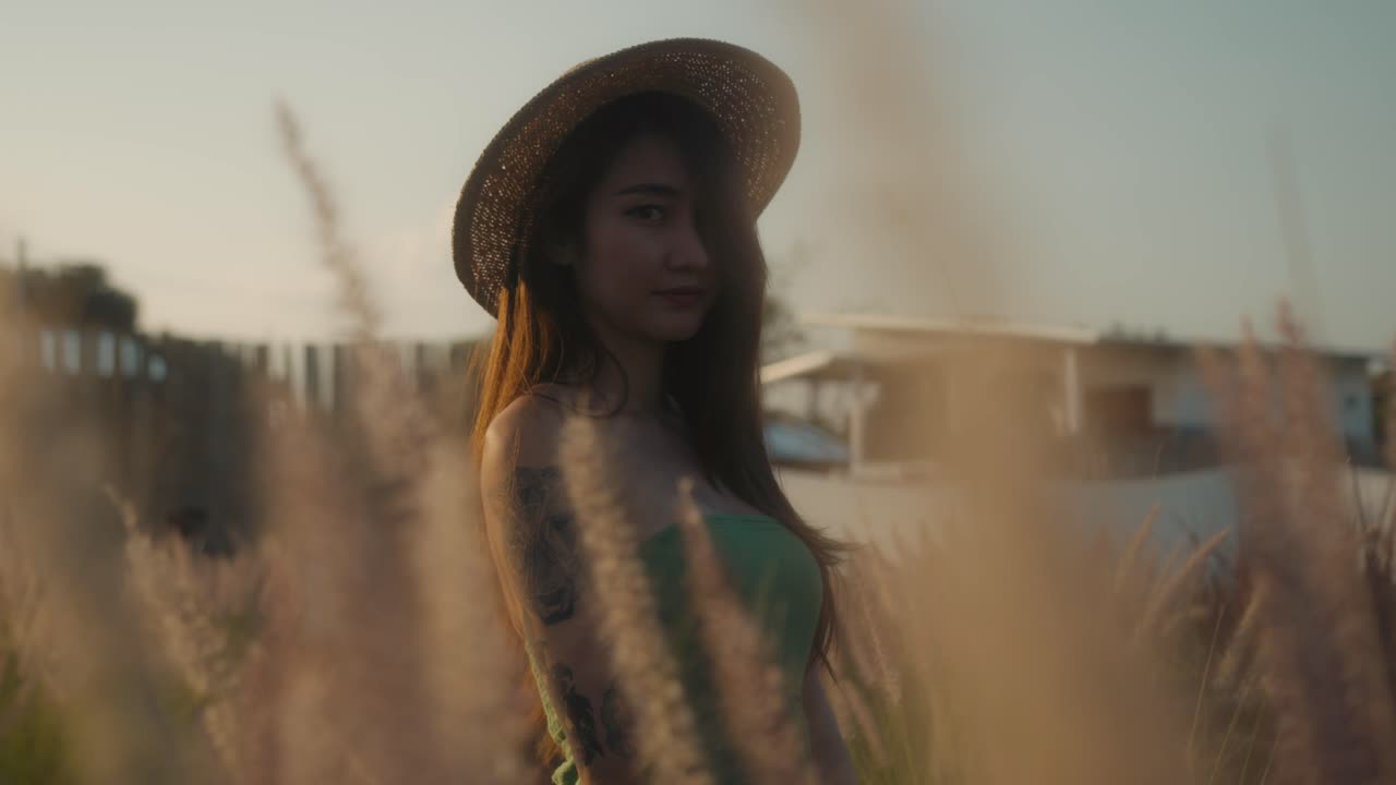 Woman in a straw hat, outdoors in a field