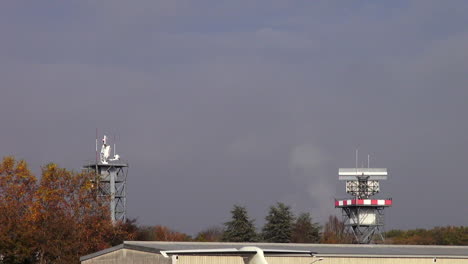 shot of 2 radars spinning around at an airport on a cloudy day