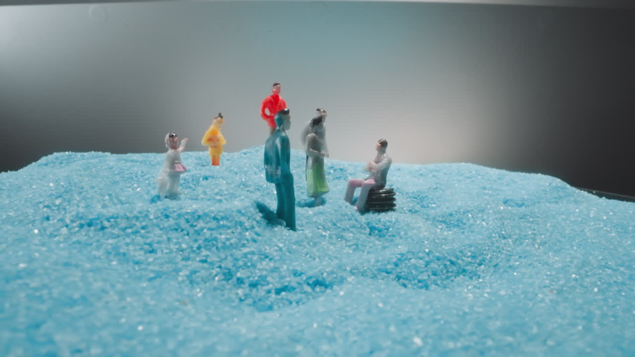 Figures of men and women tourists standing on soft blue sand