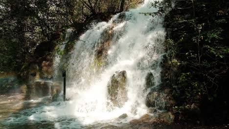 Geschwollener-Fluss-Fließt-Die-Felsen-Hinunter,-Schneller-Fluss-Des-Waldwasserfalls,-Schöne-Waldlandschaft,-Statisch