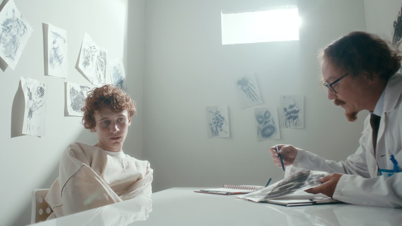 Psychiatrist Showing Abstract Drawing to Restrained Patient on Clinical Session