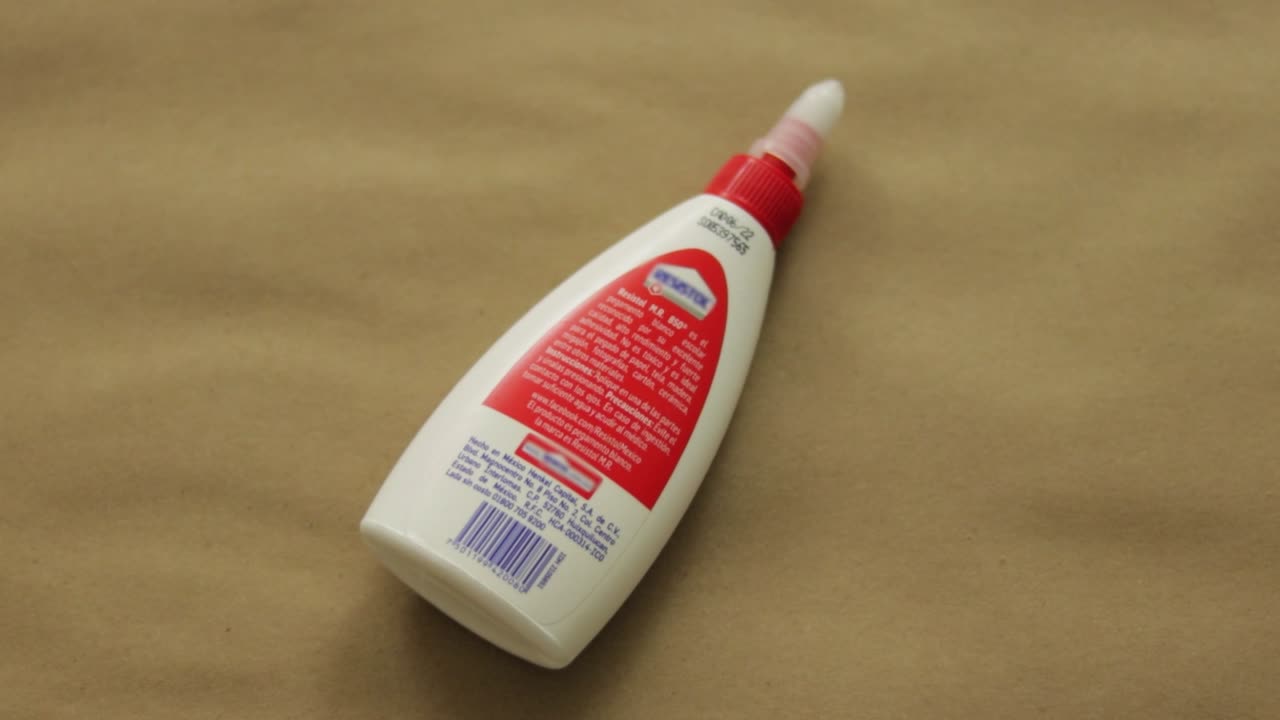 pegamento de artesanía blanco salpicado sobre un fondo de papel