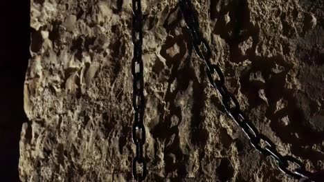 cadena de hierro colgada en los viejos muros de la terrible prisión medieval donde la gente torturaba