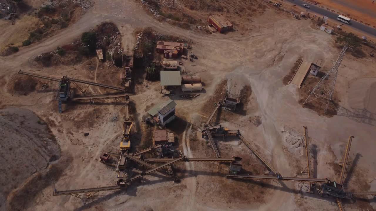 Drone flying over building and industrial equipment on a large mining site in Abuja, Nigeria on a sunny day