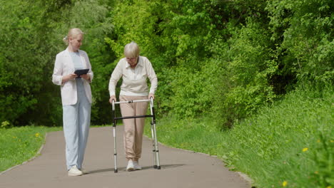 elderly woman walking with walker, assisted by healthcare professional