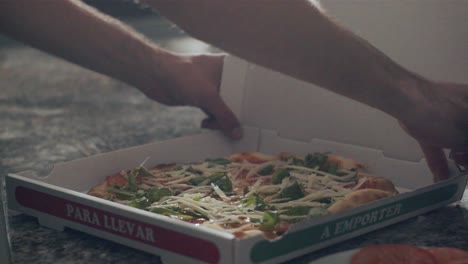 cook preparing pizza for delivery on kitchen