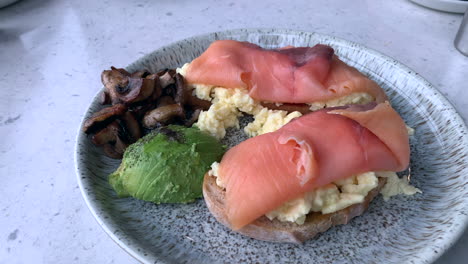 Frühstück-Serviert-In-Einem-Café,-Lachs,-Bruschetta,-Eier,-Pilze-Und-Avocado