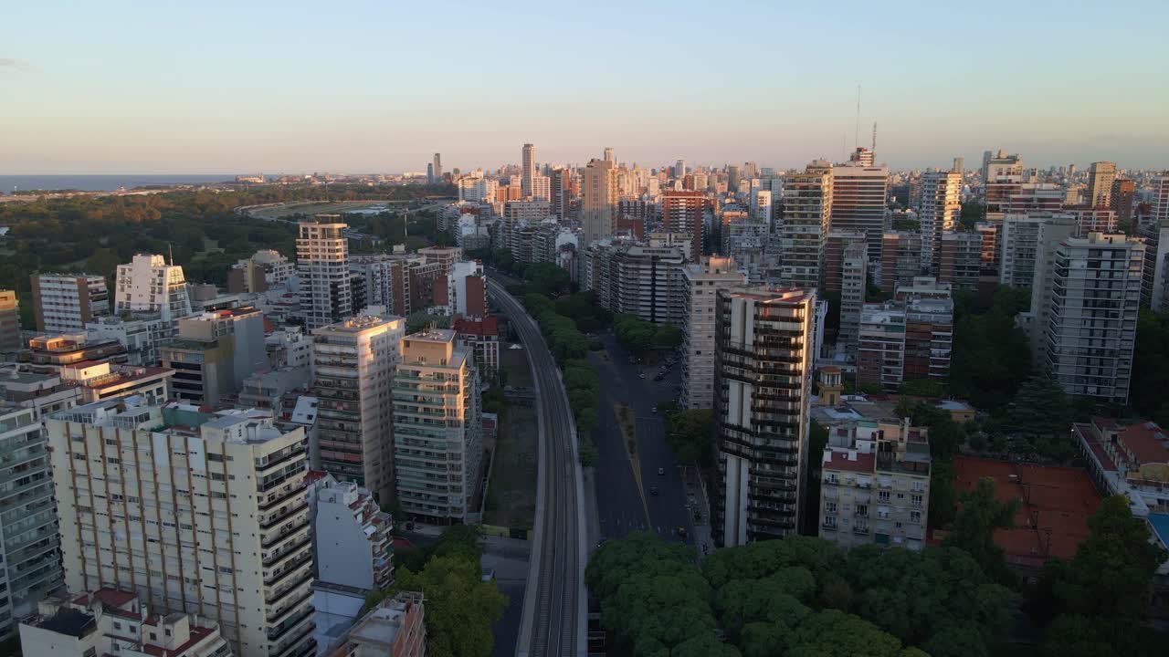 dolly volando sobre los rieles del tren cerca del parque en el barrio de belgrano con el río al fondo, buenos aires, argentina