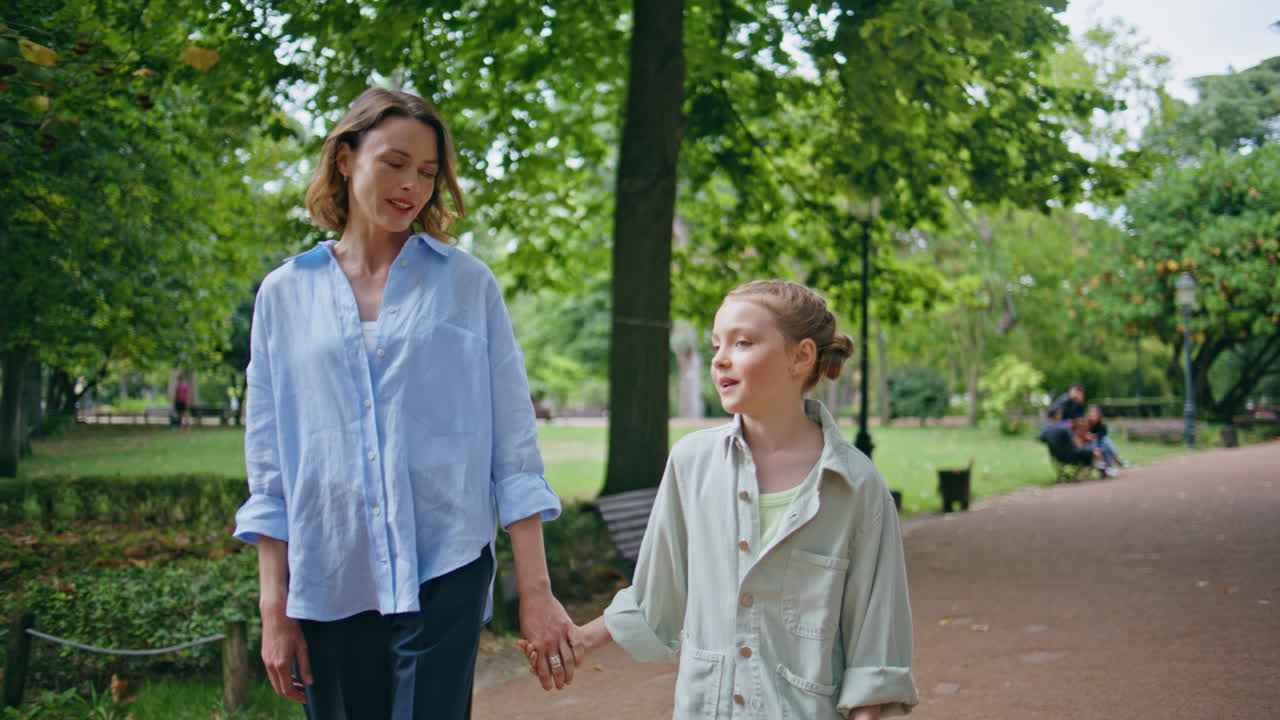 Happy mom child walking sprawling park. Family exploring green garden
