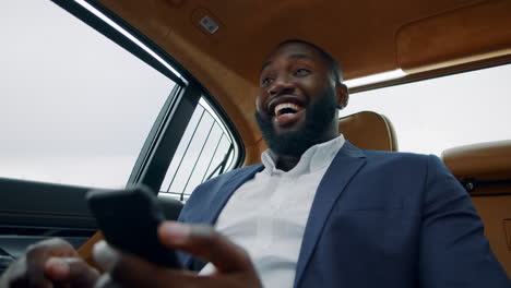 happy businessman celebrating victory at car