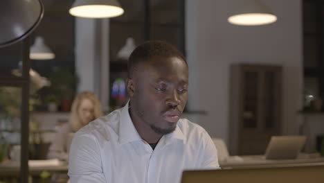 Serious-American-Man-Working-On-Laptop-Computer-In-The-Office-1