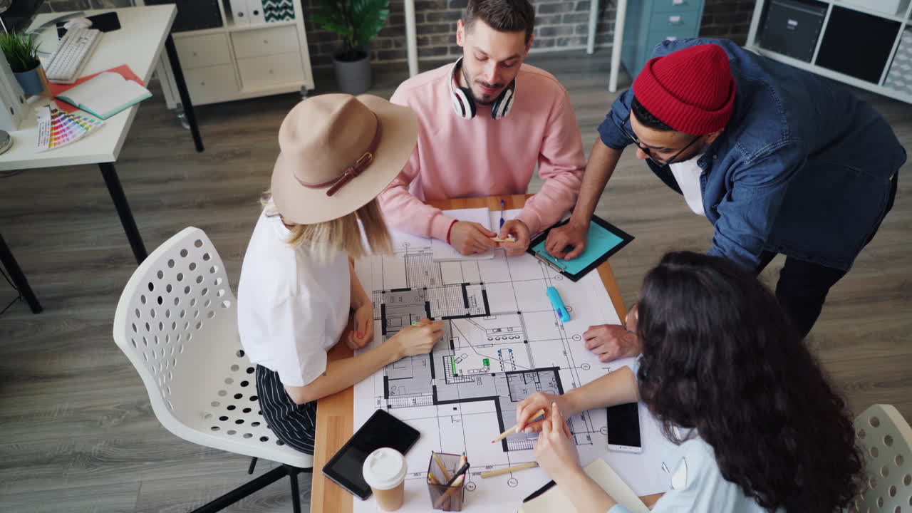 Team of young professionals working on architectural plans in a modern office