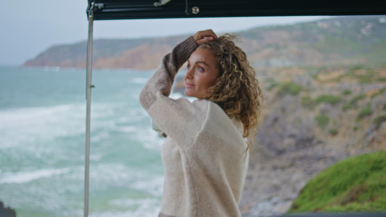Carefree woman looking seascape standing campervan terrace with coffee close up.